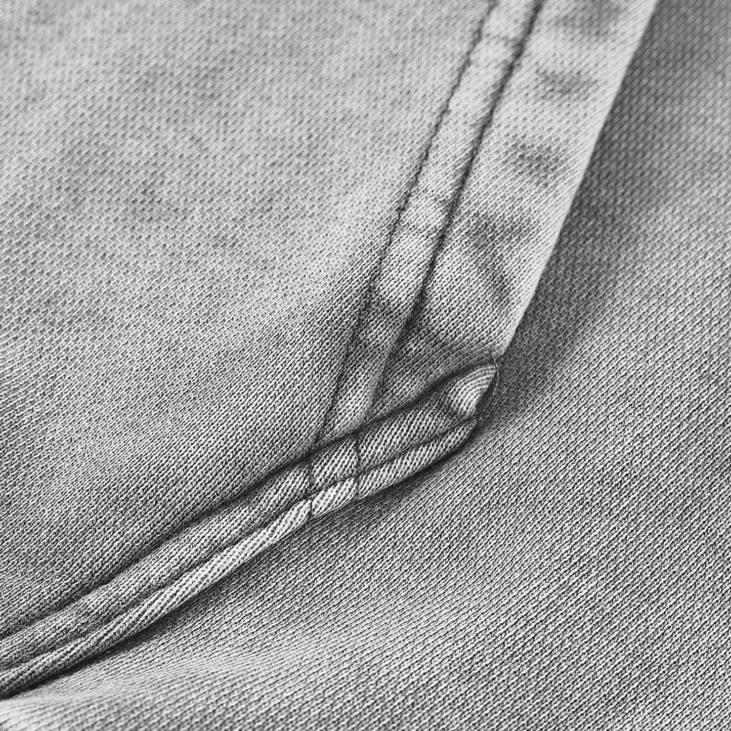 Zoomed detail of the fabric and stitching on the Kalispera oversized hoodie in acid-washed grey.