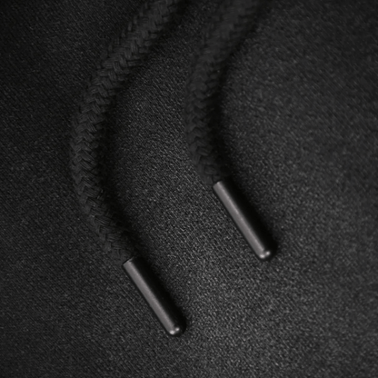 Close-up of black braided drawstrings on premium sweatpants, showcasing unique texture and quality craftsmanship.